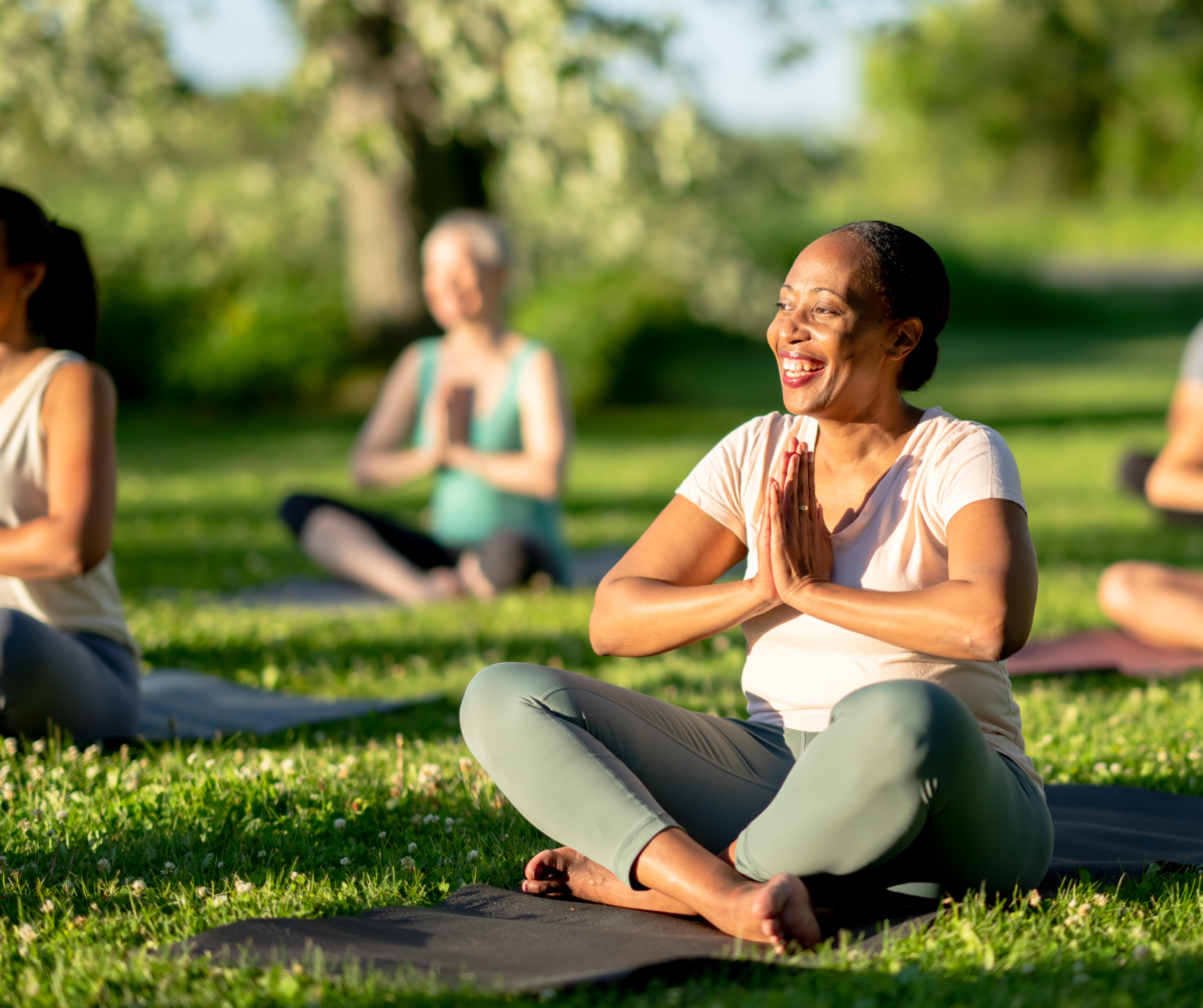 Residents practicing outdoor yoga in landscaped garden area of township